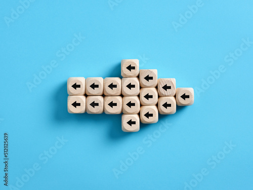 Arrow icon made of wooden cubes with little arrow icons pointing opposite direction. Resistance to change in business