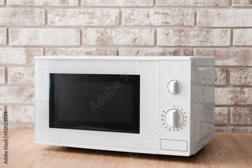 New modern microwave oven on wooden table