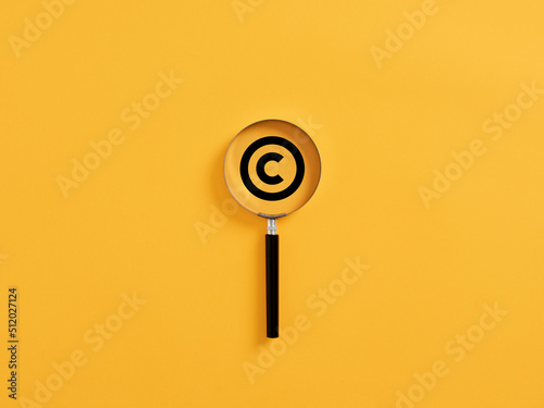 Magnifying glass magnifies copyright symbol. Patenting or copyright protection.