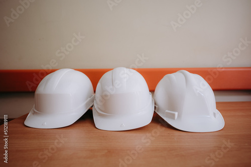 Białe ochronne kaski leżące na budowie