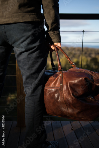 A man holding a leather bag