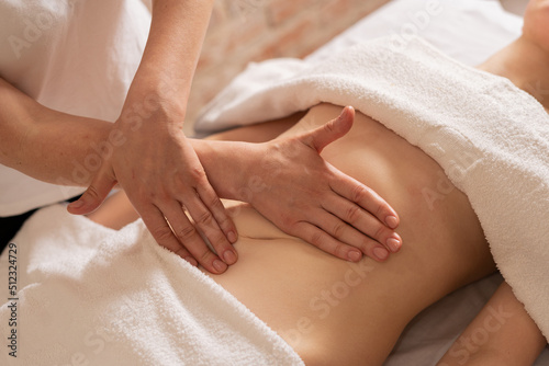 relaxing massage and body shaping massage, lymphatic drainage, manual and aesthetic procedures, hands massaging belly in the spa