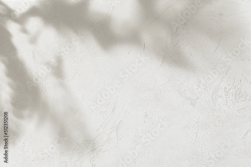 Rough concrete wall with tropical leaves shadow. Abstract background texture