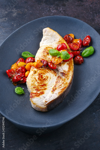 Gebratenes Schwerfisch Steak mit Tomaten und Paprika serviert als close-up auf einem Design Teller