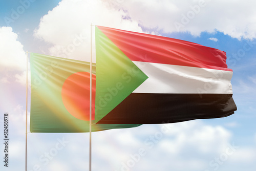 Sunny blue sky and flags of sudan and bangladesh