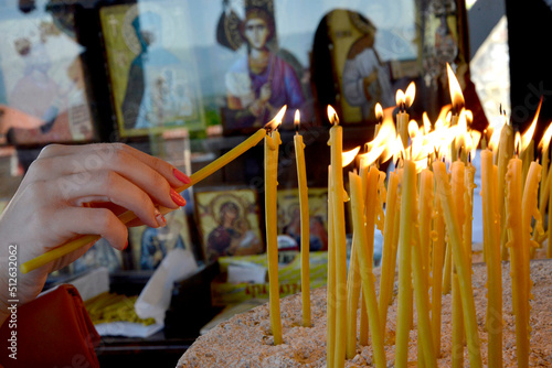 Woman lighting an ortohodx church candle
