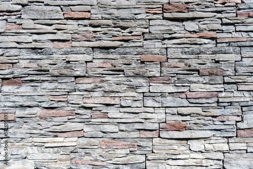 Pared de piedra en forma de ladrillo, con texturas de varios colores