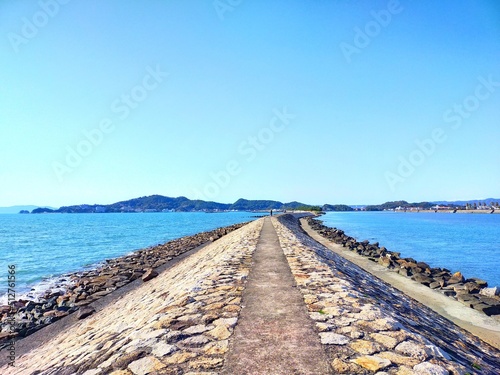 和歌山県の観光地、日本遺産和歌の浦にある片男波海水浴場の防波堤と青空と海の晴れた夏の日の爽快な風景（コピースペースあり）