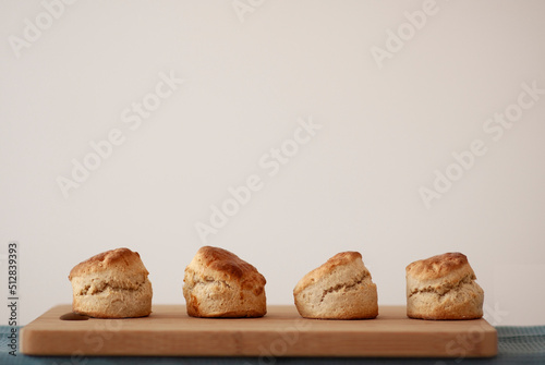  Scones - home made sweet scones on the bread board, side view on the white background 