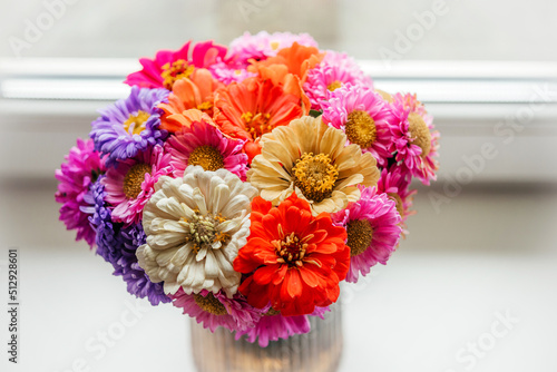 A bouquet of zinnia and aster autumn flowers on gray cement background