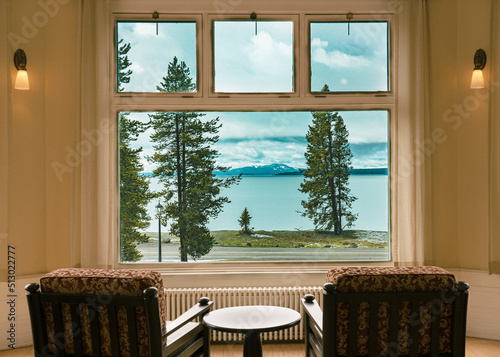 This is a view from the window of the Lake Hotel lobby in Yellowstone National Park. You can see Yellowstone Lake with pine trees and road in the foreground and mountains beyond.