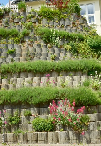 Mauer aus Pflanzringen zur Hangsicherung im Hausgarten