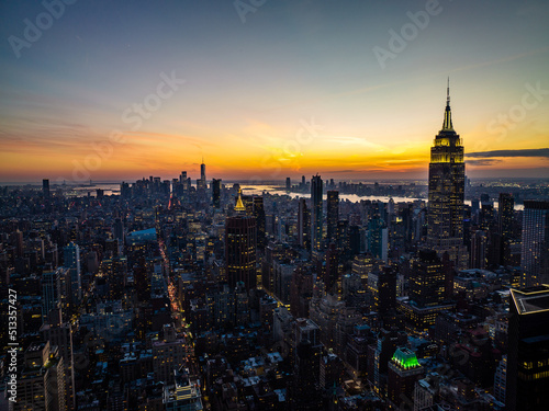 High rise buildings in arranged in blocks surrounded with streets. Cityscape against colourful sunset sky. Manhattan, New York City, USA