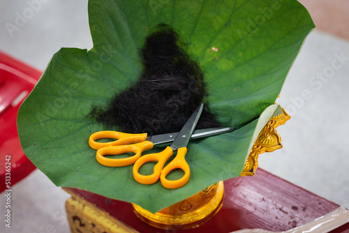 Hair, lotus leaf, scissors, ordination ceremony