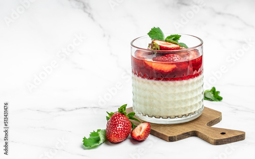 Italian panna cotta dessert with strawberry and mint on a light background. Summer yogurt dessert. space for text