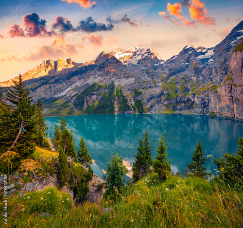 Superb summer sunrise on unique Oeschinensee Lake. Spectacular morning scene in the Swiss Alps with Bluemlisalp mountain, Kandersteg village location, Switzerland, Europe.