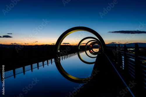 view of the Falkirk Wheel at sunset with lights in different bright colors