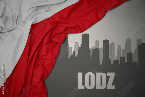 abstract silhouette of the city with text Lodz near waving national flag of poland on a gray background.