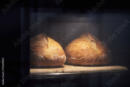 The process of making wheat bread at home. Baking bread in the oven. The concept of healthy homemade food. Front view.