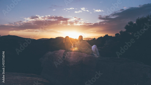 Pareja de enamorados haciendo un picnic en plena naturaleza y disfrutando del atardecer en la Sierra Calderona (Valencia)