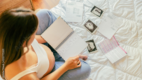 Pregnancy list woman writing. Beautiful pregnant woman writing check list. Happy pregnancy lady holding notepad. Concept maternity, childbirth.