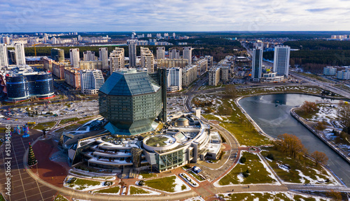 View from drone of rhombicuboctahedron-shaped building of National Library of Belarus on background with modern winter cityscape of Minsk ..