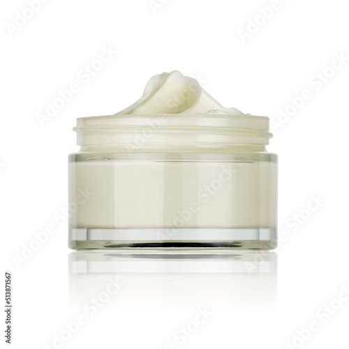 glass jar of beauty cream opened and placed on the side and reflected in the white plane