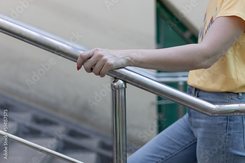 woman climbing the stairs holding the handrail