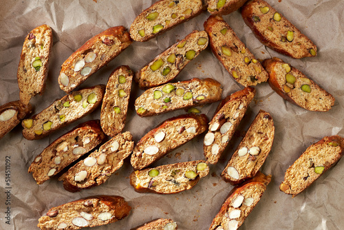 Top view of sliced freshly baked traditional homemade italian sweet cookies cantuccini on the paper and white wooden boards