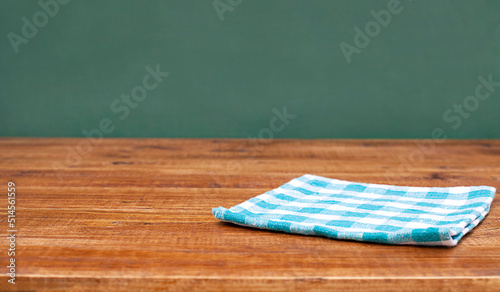 textile napkin on a wooden table against a green wall