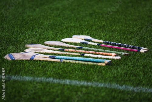 A bunch of camogie ash hurleys lie in the grass