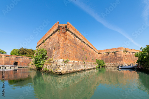 View of the brick outer walls of the Fortezza Nuova, or new fort from a canal in the New Venezia region of the port of Livorno, Italy.