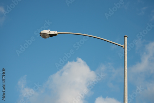 street lamp post with blue sky and white clouds