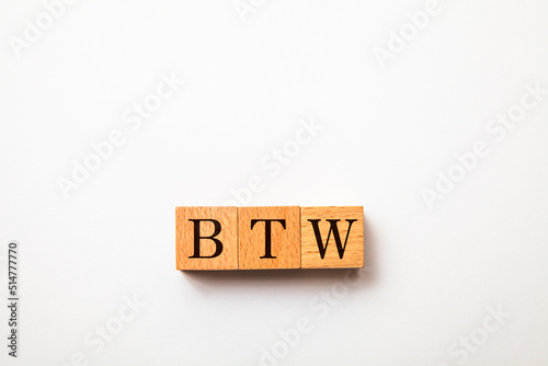 BTWの文字。ところで。3つの木製ブロックに書かれている。黒い文字。白い背景。