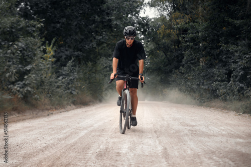 Cyclist rides gravel bike in the forest. Man cycling in the nature.