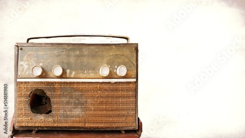 A very old, damaged radio player with an old picture background.