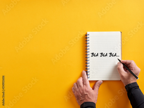 Male hand writing bla bla bla on a notepad. Business concept for talking too much with false information or gossip nonsense speaking.