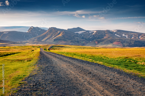 Typical icelandic landscape of empty country road with volcanic mountains on background. Colorful summer scene of south coast of Iceland, Europe. Traveling concept background.