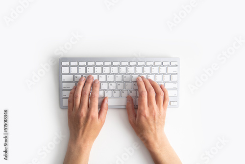 Female hands on the keyboard on a white background. Top view, flat lay