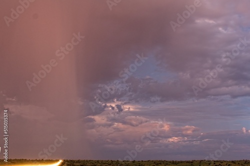 Car headlights streak down a road in a storm in the desert of Cottonwood, Arizona.