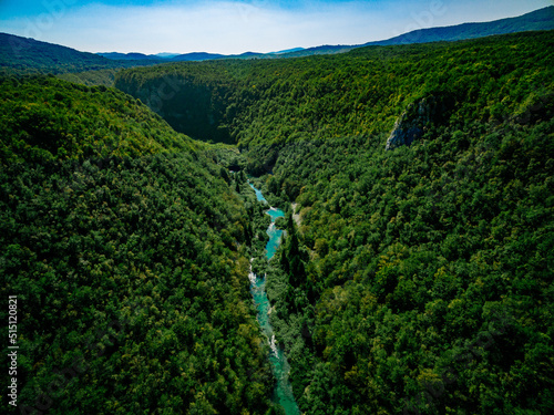Aerial view of deep green woods canyon with turquoise river in summer Croatia.