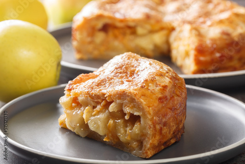 apple cheddar pie combines a buttery cheddar cheese pie crust and a sweet gooey cinnamon apple filling closeup in the plate on the table. Horizontal