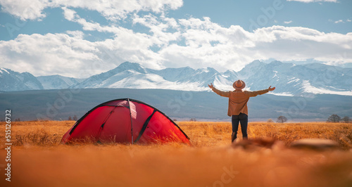 Young traveler man in hat standing background mountains sunset, beautiful view of nature. Concept banner travel trekking