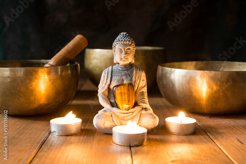 Still life with Tibetan singing bowls, minerals, candles and a Buddha figure.