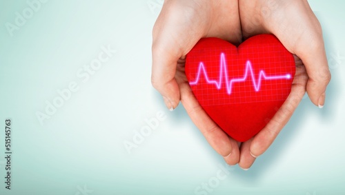 World Hypertension Day. Adult holds a red heart with a heartbeat chart, a symbol of high blood pressure.