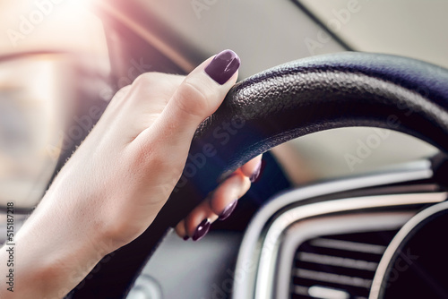 female hand is holding the steering wheel of a car. close up. Traveling alone. Traffic Laws. Learns to drive a car. woman driver