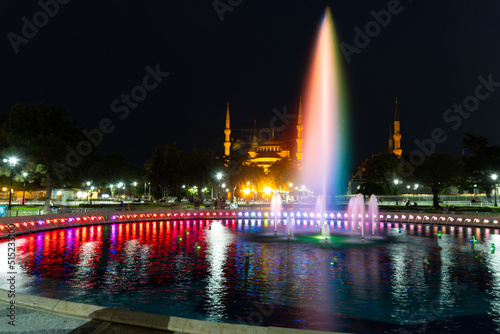 Blue Mosque in Istanbul illuminated at night, with the colored fountain in front, with a long exposure, the water looks like silk.