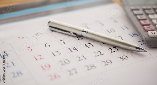 Calendar, calculator and pen on the desk.