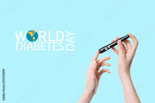 Close up picture of hand holding lancete pen and ,,WORLD DIABETES DAY''