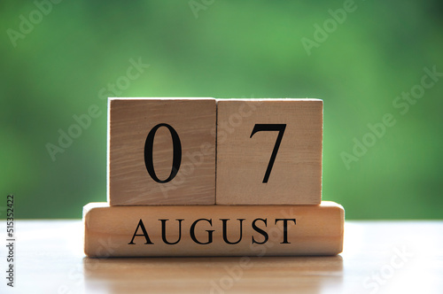 August 7 calendar date text on wooden blocks with blurred background park. Copy space and calendar concept